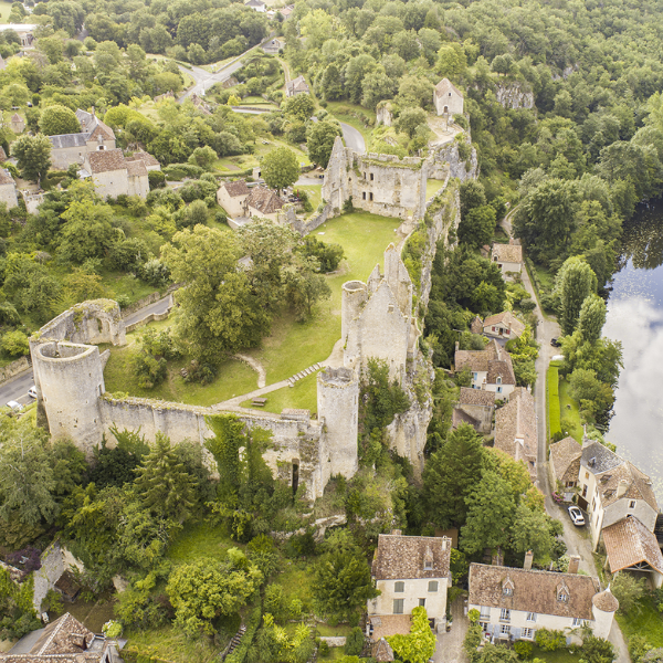 Vue aérienne plongeante sur la forteresse d’Angles-sur-l’Anglin, entourée de son village et de la vallée verdoyante