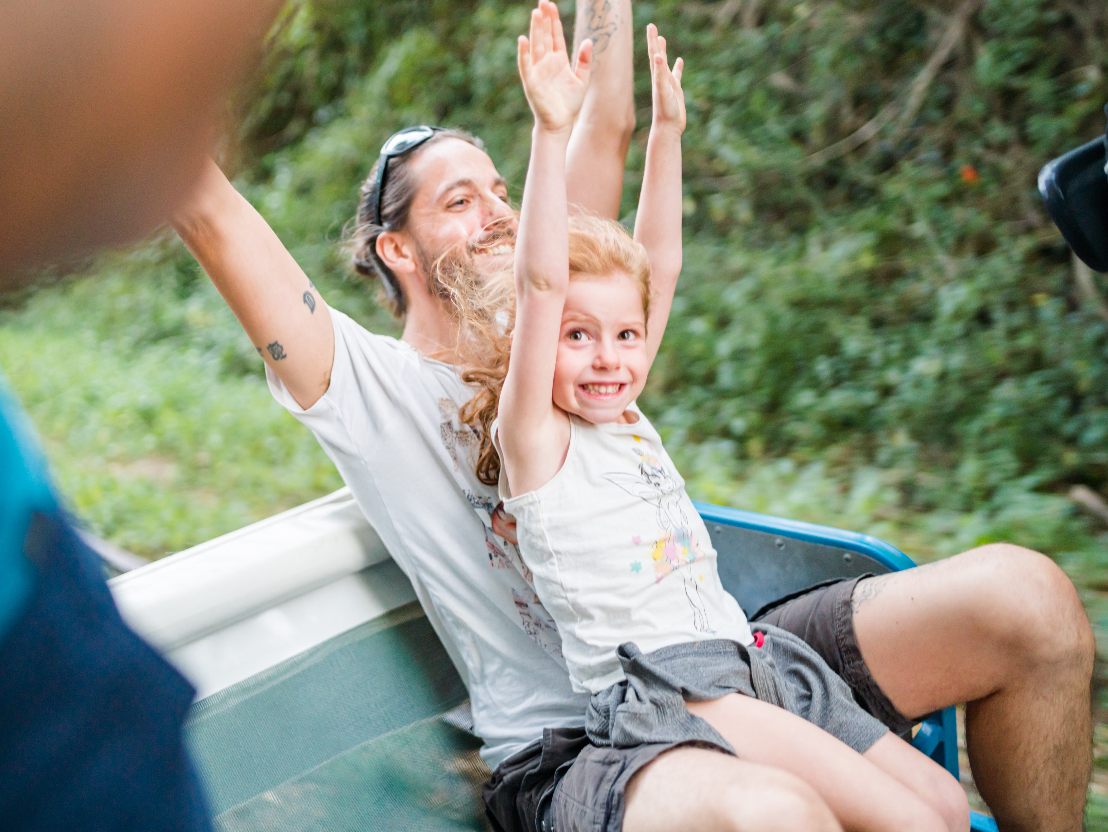 Une famille joyeuse en vélorail traversant une forêt verdoyante, idéale pour une sortie nature en famille dans la Vienne
